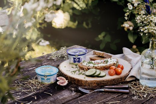 Jausenplatte auf Holztisch mit Schaf- und Ziegentopfen