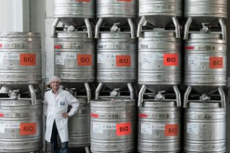 Behälter in Produktion mit Person davor stehend